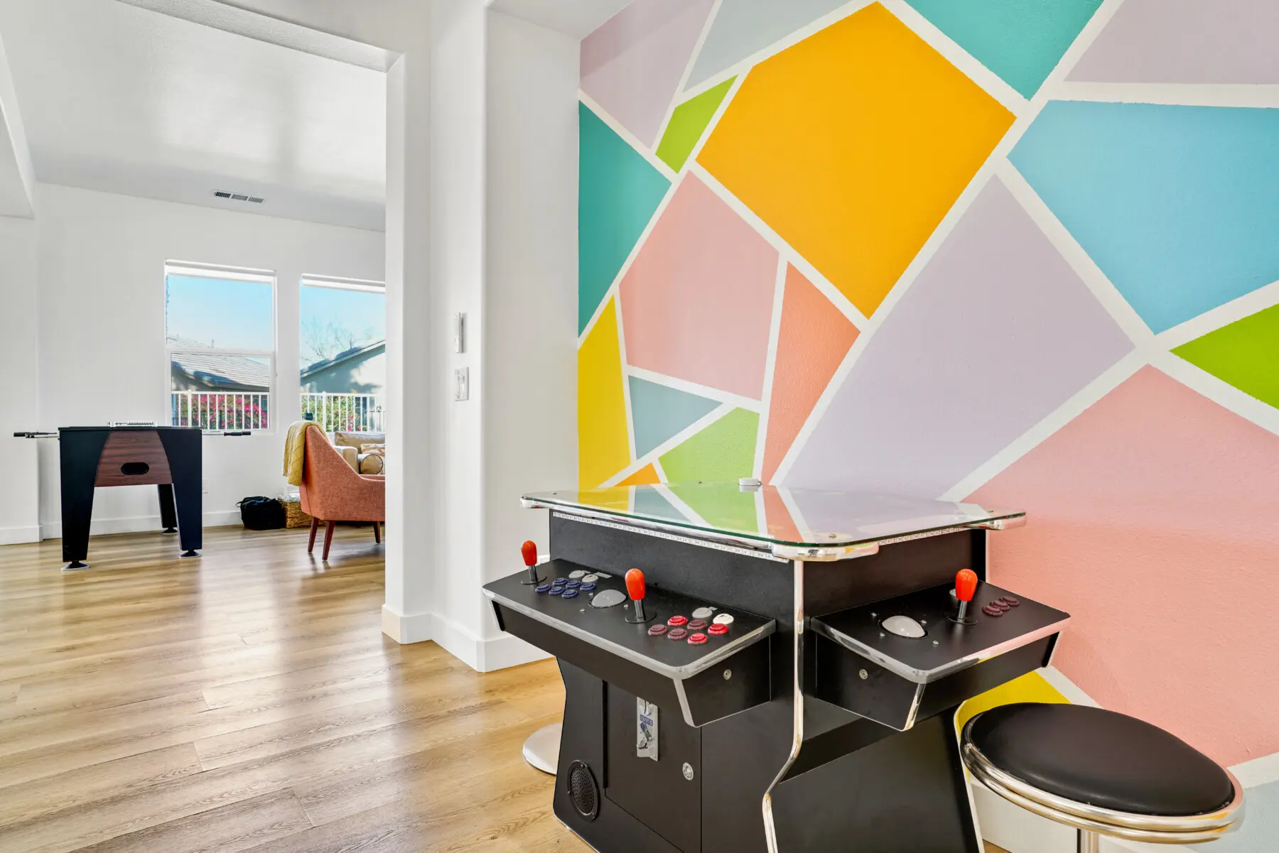 Arcade game and colorful geometric mural wall in games room at Indio CA vacation rental