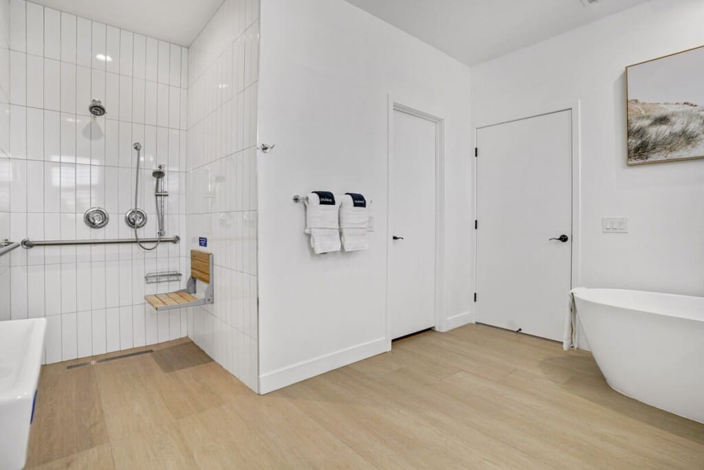 Roll-in shower with fold-down seat and grab bars at Indio Access wheelchair accessible rental near Acrisure Arena