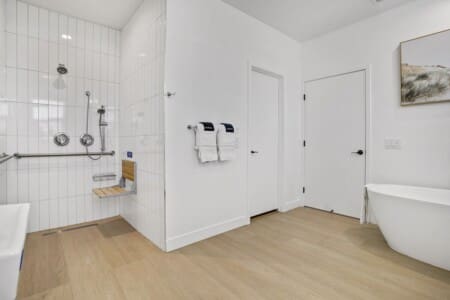 Roll-in shower with fold-down seat and grab bars at Indio Access wheelchair accessible rental near Acrisure Arena