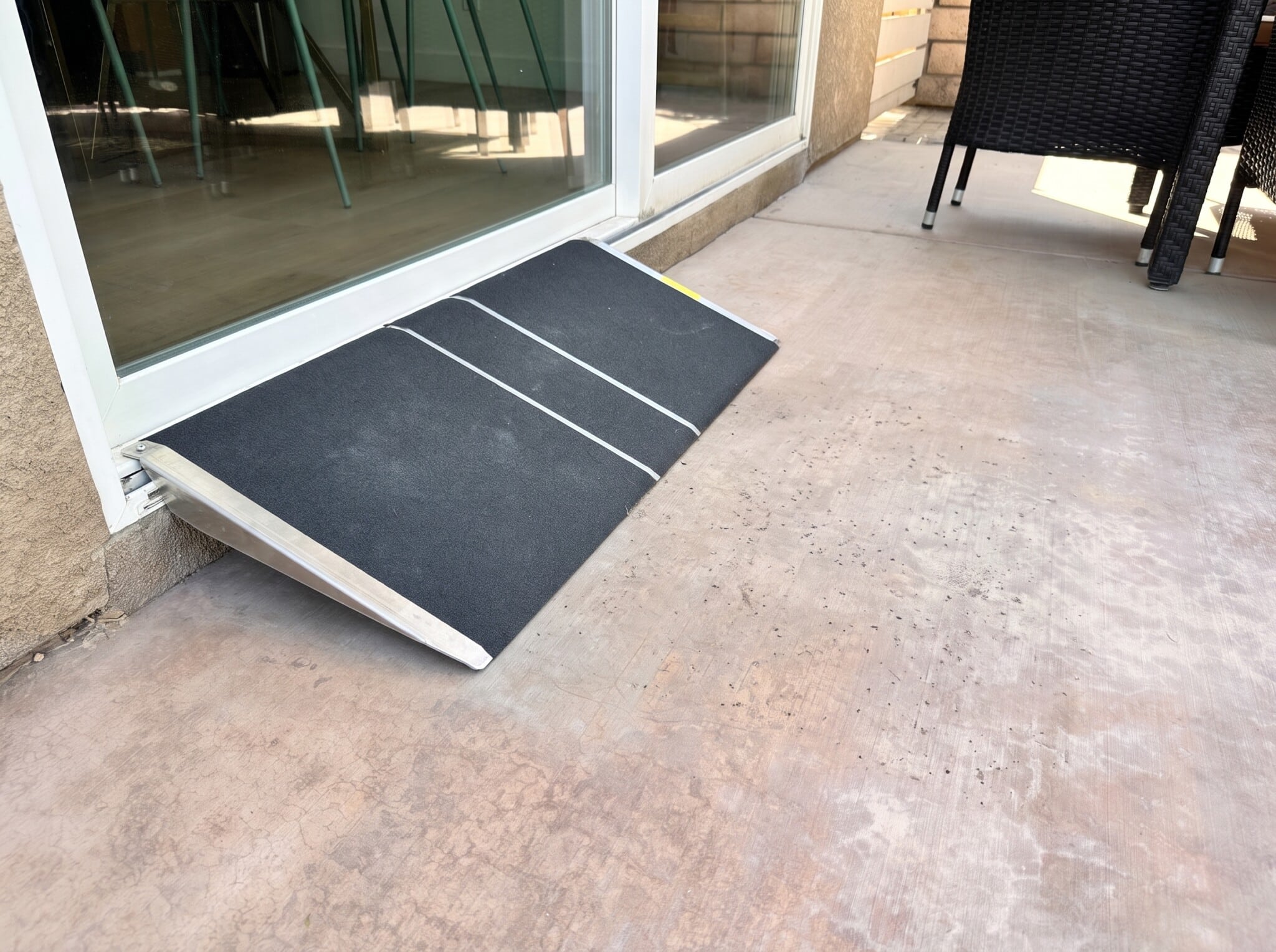 Portable threshold ramp at sliding door to flat patio